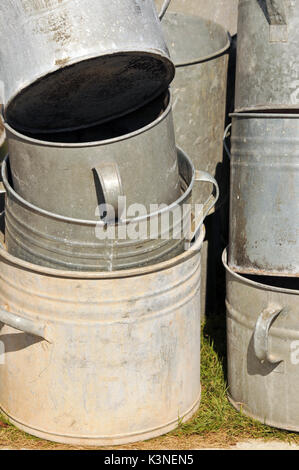 Un assortimento di raccolta in acciaio galvanizzato di bacini secchi e vasche per uso nel giardino di vecchio stile per il lavaggio e l'ora del bagno. Foto Stock