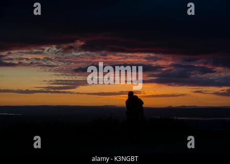 Un paio di coccolare come guardare il tramonto dal picco Coaley nel Gloucestershire. Foto Stock