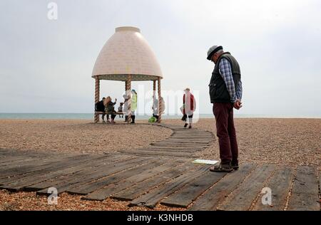 Visitatori guardare un pezzo da Lubaina Himid chiamato stampo per gelatine Pavilion sulla spiaggia in Folkestone, Kent durante la Triennale di Folkestone arts evento. Foto Stock