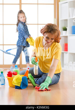 La famiglia felice pulisce la camera. Madre e figlia fare pulizia in casa. Foto Stock