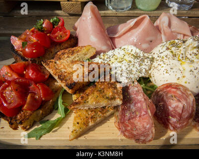 Una diffusione di affettati e cibo italiano a pranzo Foto Stock