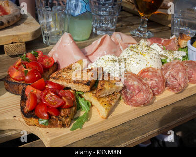 Una diffusione di affettati e cibo italiano a pranzo Foto Stock