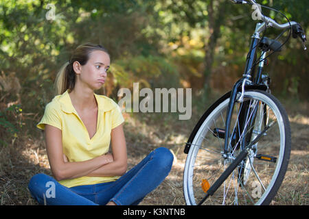 Giovane donna sportive con moto rotti nella foresta Foto Stock