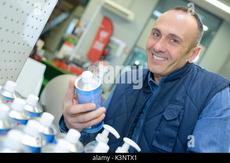 Shop assistant riordino productos sullo scaffale Foto Stock