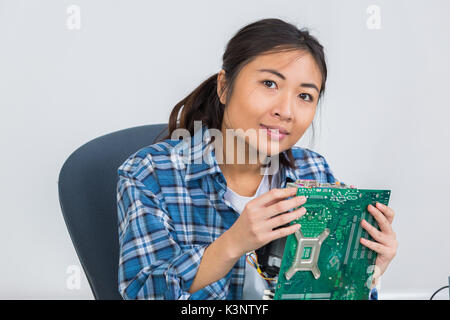 Tecnico femminile di saldatura della scheda madre del computer Foto Stock