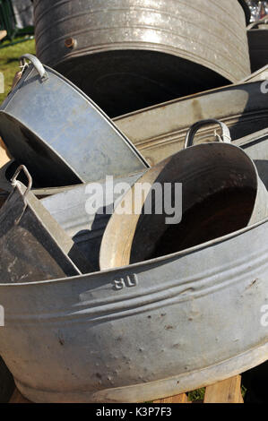 Un assortimento di raccolta in acciaio galvanizzato di bacini secchi e vasche per uso nel giardino di vecchio stile per il lavaggio e l'ora del bagno. Foto Stock