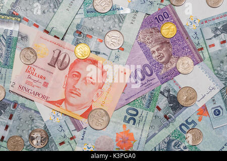 Dollaro di Singapore e le monete sulla parte superiore di ringgit malese valuta su pattern di sfondo, ringgit malese simbolo è RM codice di valuta MYR, Singapore Dol Foto Stock