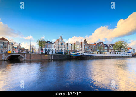 Cielo blu e nuvole sul case tipiche riflessa nel canale del fiume Spaarne Haarlem Olanda settentrionale dei Paesi Bassi in Europa Foto Stock