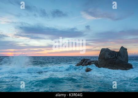 Il tramonto sulle onde del mare blu che si infrangono sulle rocce di Capo Testa a Santa Teresa di Gallura in provincia di Sassari Sardegna Italia Europa Foto Stock