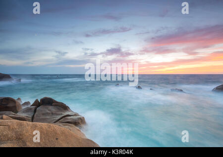 Il Fiery sky telai le onde che si infrangono sulle rocce di Capo Testa a Santa Teresa di Gallura in provincia di Sassari Sardegna Italia Europa Foto Stock