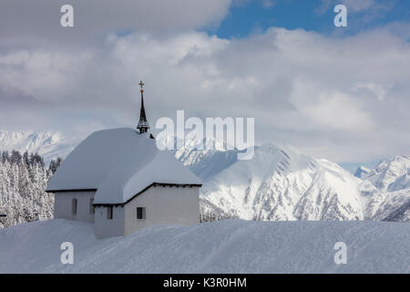 La chiesa alpino immerso nel frame di neve le cime più alte di Bettmeralp distretto di Raron nel canton Vallese Svizzera Europa Foto Stock