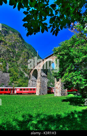 Il Bernina Express sotto il viadotto di Brusio, Val Poschiavo, Svizzera Europa Foto Stock