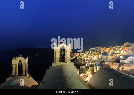 Vista notturna di Oia con il bianco chiese e case e sul blu del Mar Egeo come simboli di Grecia Santorini Cyclades Grecia Europa Foto Stock