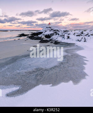 Artico colorato tramonto sul faro circondato da ghiaccio e neve Eggum Vestvagoy Island Isole Lofoten in Norvegia Europa Foto Stock