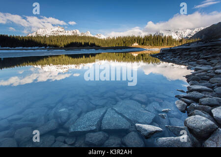 La molla del disgelo si scioglie il ghiaccio mentre vette innevate sono riflesse nel lago Palù Sondrio Malenco Valley Valtellina Lombardia Italia Europa Foto Stock