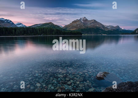 Alba illumina i picchi si riflette nelle calme acque del lago di Sils Engadina Canton Grigioni Svizzera Europa Foto Stock