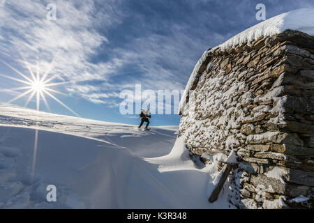 Gli escursionisti con racchette da neve a piedi vicino coperta di neve hut Motta di Olano Gerola Alta Valtellina Alpi Orobie Lombardia Italia Europa Foto Stock