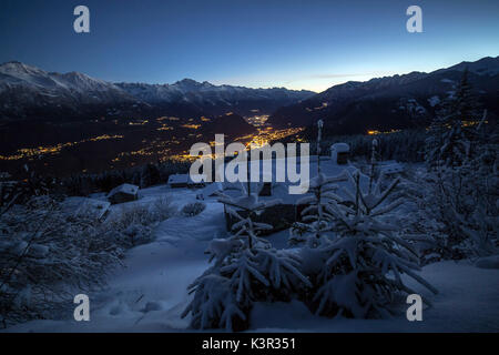 Luci del tramonto illuminano la valle e la coperta di neve di capanne tagliate di sopra di Gerola Alta Valtellina Lombardia Italia Europa Foto Stock