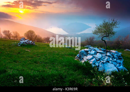 Il lago d'Iseo, al tramonto. L'isola di Monte Isola nel mezzo del lago, chiuso nelle montagne che dividono le due province di Bergamo e Brescia Foto Stock