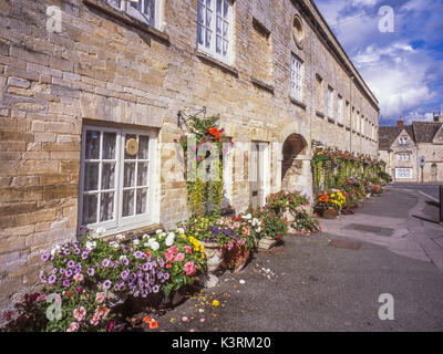 La storica, inizi del XIX secolo, pietra Tontine edifici, con fiori in mostra, in Cecily Hill, Cirencester, Cotswolds, Gloucestershire, Inghilterra, Regno Unito. Foto Stock