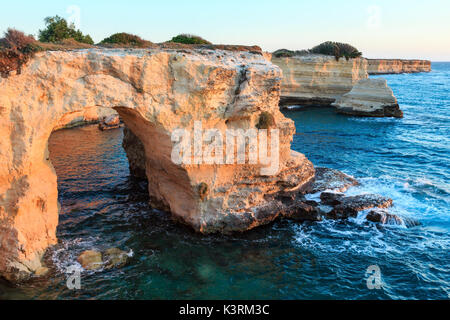 Il pittoresco paesaggio marino con scogliere, arco roccioso e pile (faraglioni), a Torre Sant'Andrea in luce del sole di mattina, mare Salentino costa, Puglia, Italia. Foto Stock