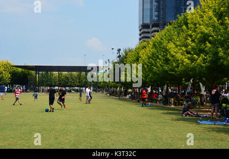 Il prato di Klyde Warren Park offre uno spazio aperto per i residenti per la riproduzione e la sede aperta per il padiglione della musica. Foto Stock