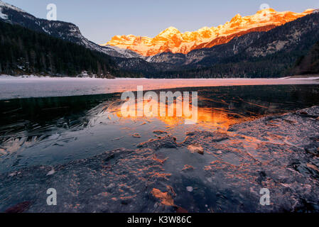 Sunrise Tovels lago in una fredda giornata invernale, Parco Naturale Adamello Brenta, Val di Non, in Trentino Alto Adige, Italia. Foto Stock