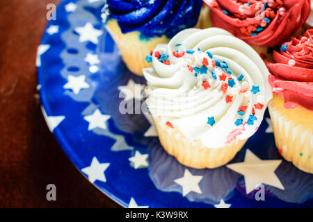 Tortini multicolore su una piastra di blu - il concetto di partito Foto Stock