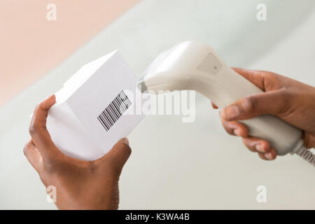 Persona della mano la scansione di codice a barre sul prodotto con uno scanner di codici a barre Foto Stock