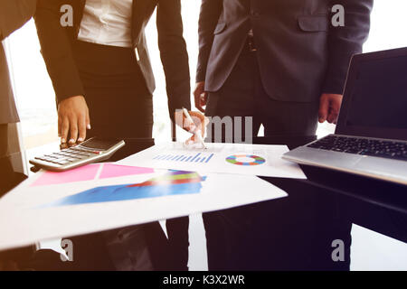 Gruppo misto di persone in riunione aziendale lavora con documenti e computer Foto Stock