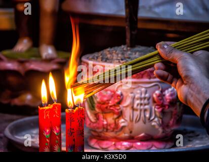 Candele accese come offerta a un tempio buddista, Hanoi, Vietnam. Foto Stock