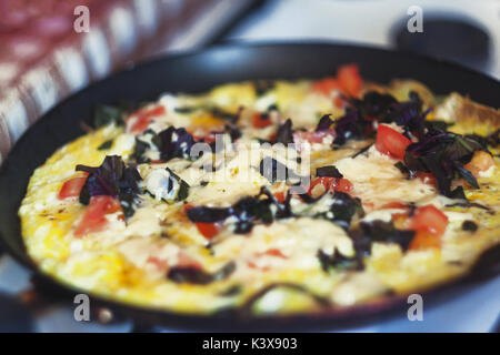 Frittata con verdure in una padella sul fornello. Foto Stock