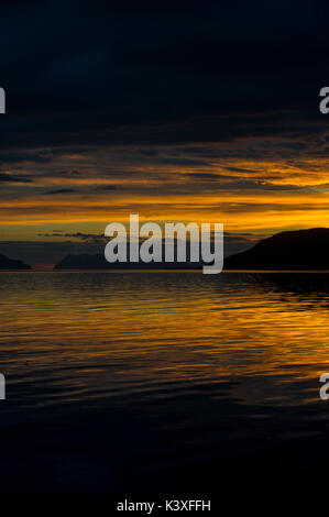Sunrise riflessa nel mare in Lyngenfjord a nord del Circolo Polare Artico, Norvegia durante l'estate. Foto Stock