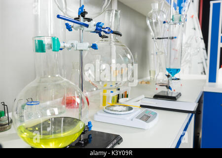 Area di lavoro con le provette e matracci con liquido diverso. Assistenza sanitaria e il concetto di biotecnologia Foto Stock