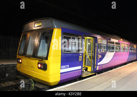 Classe Pacer 142 diesel multiple unit treno visto di notte in Lancaster stazione ferroviaria nella piattaforma di baia numero 2. Foto Stock