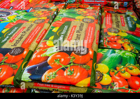 Una pila di ampio orizzonte nuovo Instant piantatrice crescere borse in un garden center utilizzati per la coltivazione di piante di pomodoro peppersor altre piante simili Foto Stock