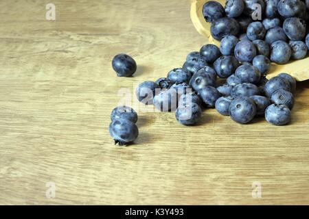 I mirtilli su una tavola di legno di fuoriuscita del cestello Foto Stock