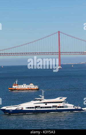 Il 25 de Abril ponte sopra il fiume Tago a Lisbona, la capitale e la città più grande del Portogallo nel quartiere di Alfama Foto Stock