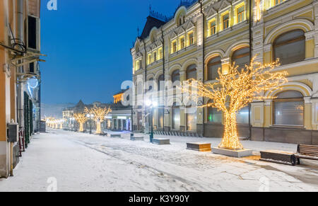 Decorato per il Natale e il nuovo anno coperto di neve street. Via centrale con edifici storici della città di Mosca Foto Stock