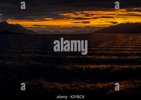 Sunrise riflessa nel mare in Lyngenfjord a nord del Circolo Polare Artico, Norvegia durante l'estate. Foto Stock