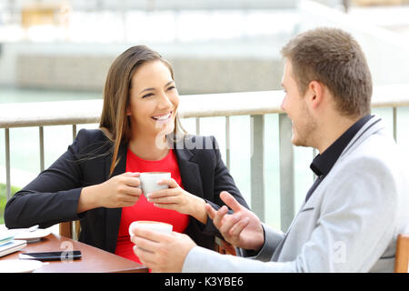 Due dirigenti felici parlando durante una pausa caffè seduti in un bar Foto Stock