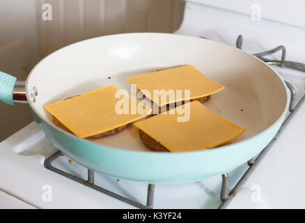 Tre veggie cheeseburger frittura sulla sommità della stufa Foto Stock