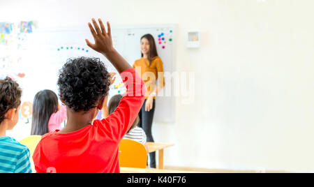 African American etnicità kid mano per rispondere alla domanda di insegnante in classe,scuola materna educazione prescolare concetto,Mock up spazio banner per un Foto Stock