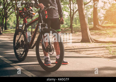 I ciclisti con bici su strada nel parco con sole splendente. Foto Stock