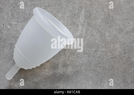 Close up di un silicone coppa mestruale su un sfondo di calcestruzzo Foto Stock