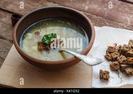 Ceca zuppa di aglio con crostini fatti in casa da vicino in una ciotola sul pannello di legno Foto Stock
