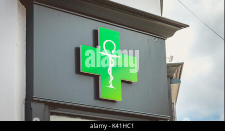 NOIRMOUTIER, Francia - Luglio 03, 2017 : croce verde su una finestra che indica la presenza di una farmacia Foto Stock