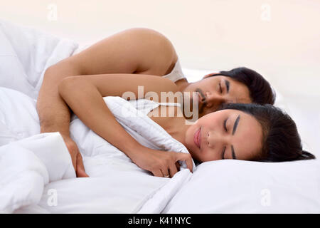 Ritratto di coppia asiatica dormire strettamente sotto coperta nel letto Foto Stock