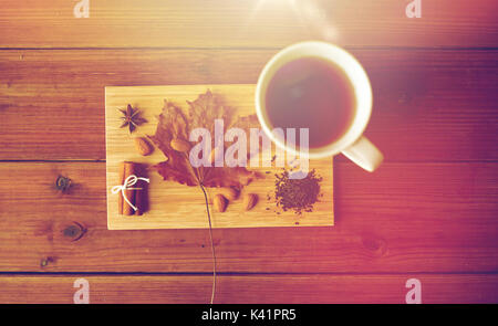 Tazza di tè, maple leaf e mandorla sul pannello di legno Foto Stock