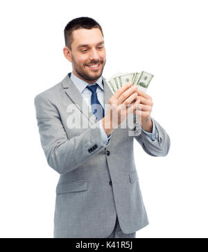 Imprenditore sorridente conteggio dollaro americano denaro Foto Stock